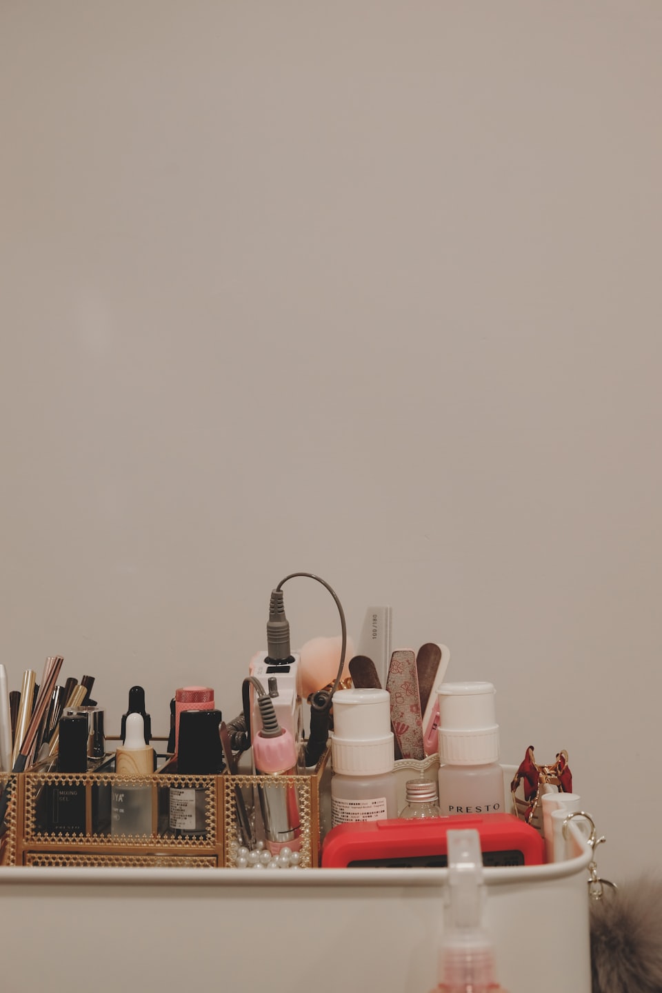 Nagellacke und Werkzeuge in einem goldenen Organizer.