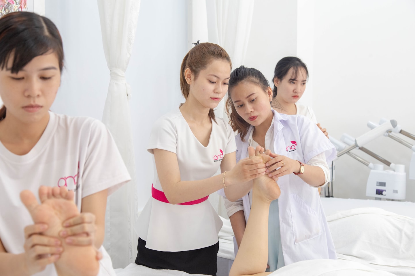 Frauen üben Fußmassagetechniken während einer Schulung.